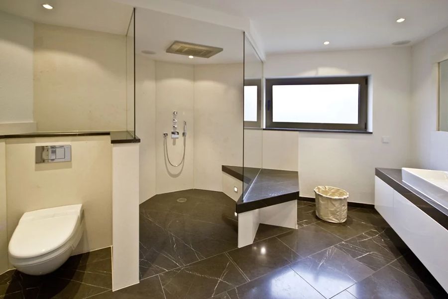 Bad mit dunklen Fließen und hellen Wänden