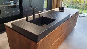 Bild Küchenzeile mit schwarzem Waschbecken. Hintergrund schwarze Schränke