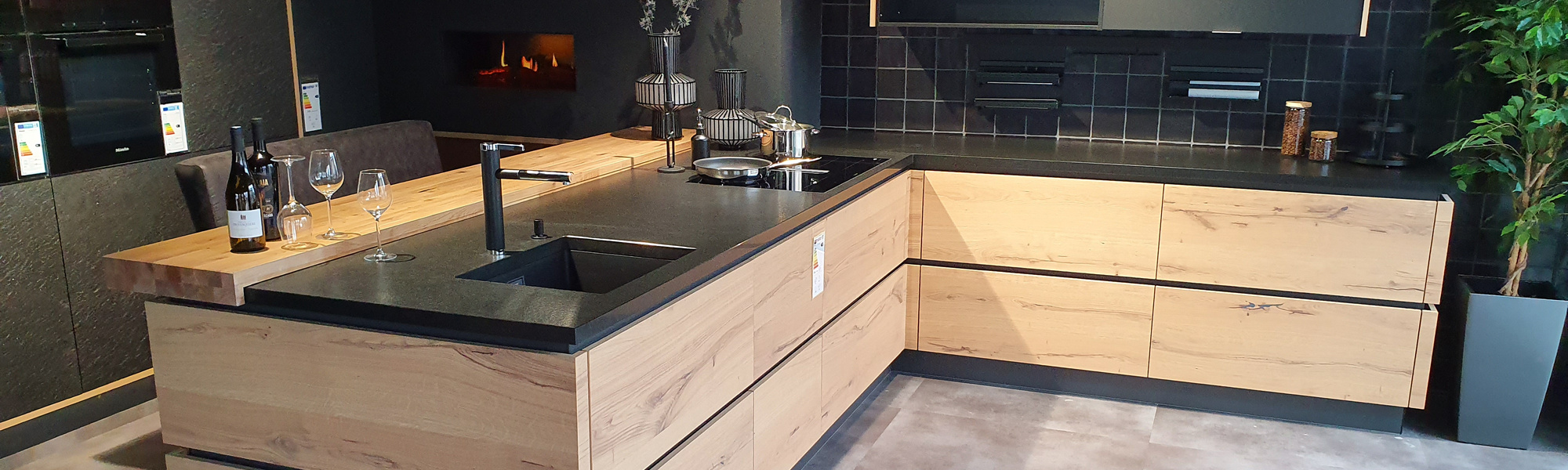 Küche mit hellen Schränken und einer dunklen Arbeitsplatte